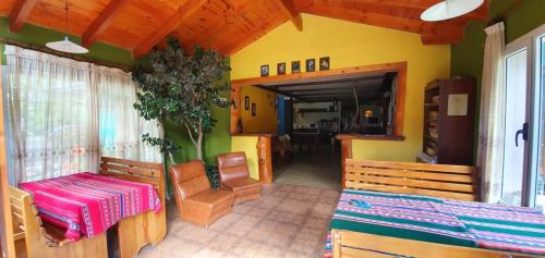 a room with two beds and a table and chairs at La Estacion Hostel in Lago Puelo