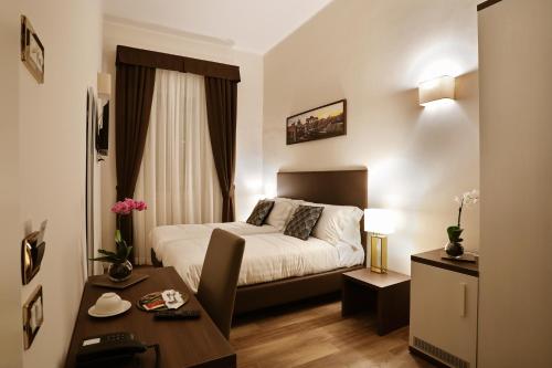 Cette chambre comprend un lit et un bureau. dans l'établissement Elegant Rooms Roma - Guest House, à Rome