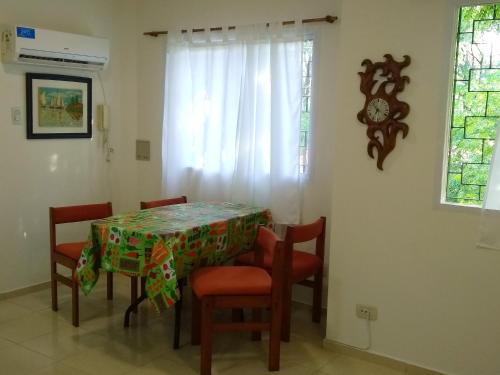 comedor con mesa, sillas y reloj en Famiglia Dtos en San Rafael