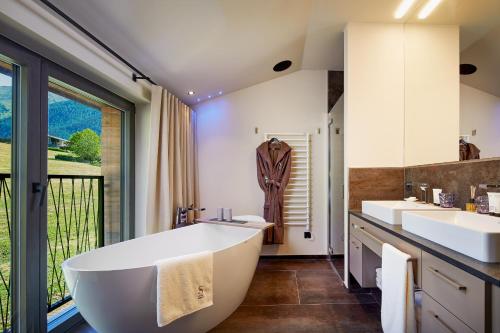 un bagno con due lavandini e una grande vasca di Chalet SALENA luxury lodge a Santa Maddalena in Casies