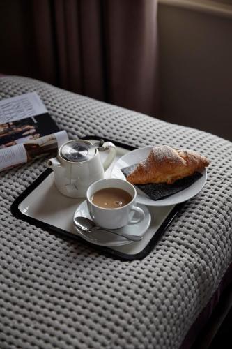 a tray with a cup of coffee and a plate of bread at Hertford House in Hertford