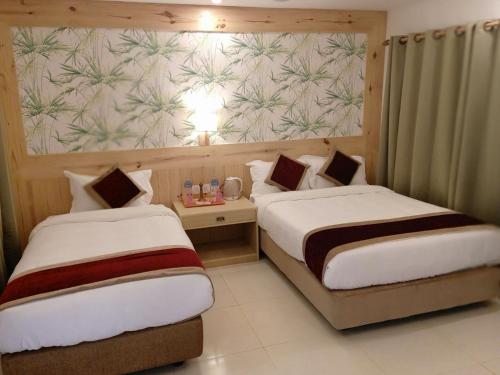 a hotel room with two beds and a wall mural at Hotel Parkland in Sauraha