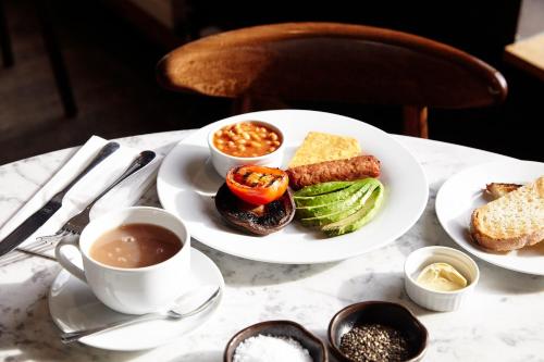 a table with a plate of food and a cup of coffee at Hertford House in Hertford