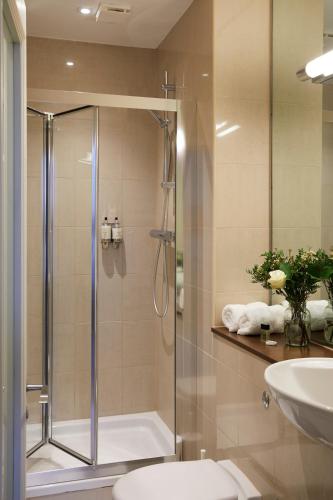 a bathroom with a shower and a toilet and a sink at Hertford House in Hertford