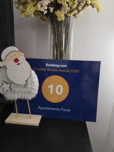 a vase of flowers with a figurine of a sheep at Apartamento Paula in Valladolid