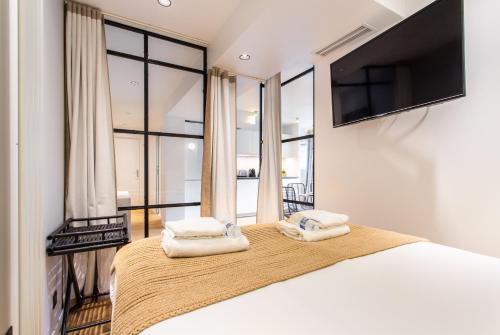 a bedroom with a large bed with two towels at CMG Résidence Canal Saint-Martin Vellefaux in Paris