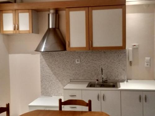 a kitchen with white cabinets and a sink at Rozy House Nei Epivates Thessaloniki ( Near the sea) in Neoi Epivates