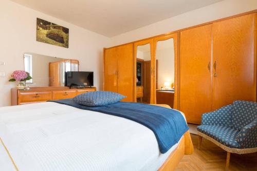 1 dormitorio con 1 cama blanca y 2 sillas en La Casa di Michela - 120m2 in the mountains with fireplace & garden, en Strigno