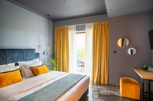 a bedroom with a bed and a window with yellow curtains at Olympus Terra Boutique Hotel in Larisa