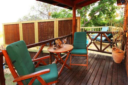 a porch with two chairs and a table on a deck at Rosh Pinat Noy in Rosh Pinna