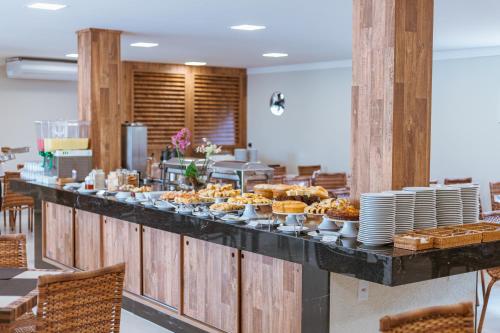 a buffet line with cupcakes and plates on at Orquídeas Praia Hotel in Porto Seguro