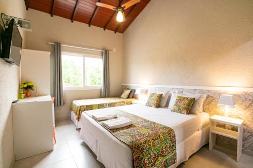 a bedroom with two beds and a window at Pousada do Frei in Búzios