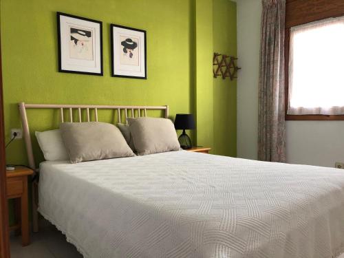 ガルチャにあるGarruchaの緑の壁の白いベッドが備わるベッドルーム1室