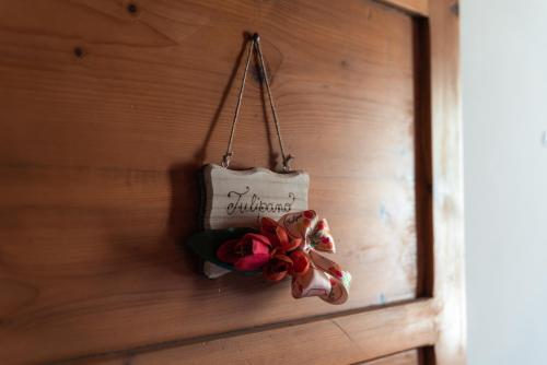 a sign hanging on a wall with a flower at Ca' le cerque, villa surrounded by the Marche nature in Fossombrone