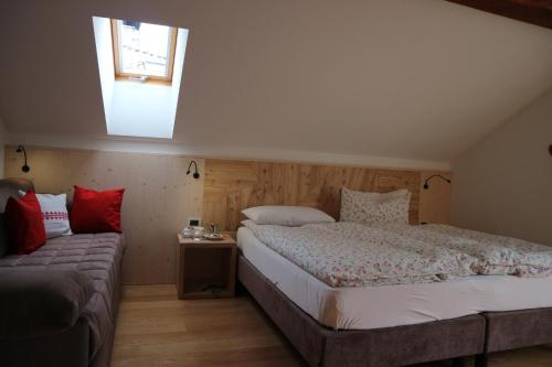 um quarto com uma cama grande e uma janela em B&B Casa Riz em Castello di Fiemme