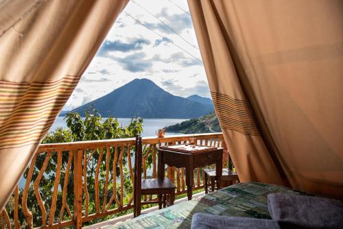 d'un balcon avec une table et une vue sur la montagne. dans l'établissement EL PICNIC ATITLÁN, à Tzununá