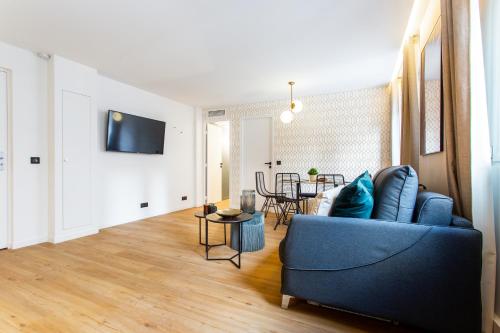 a living room with a blue couch and a table at CMG Résidence Canal Saint-Martin Vellefaux in Paris