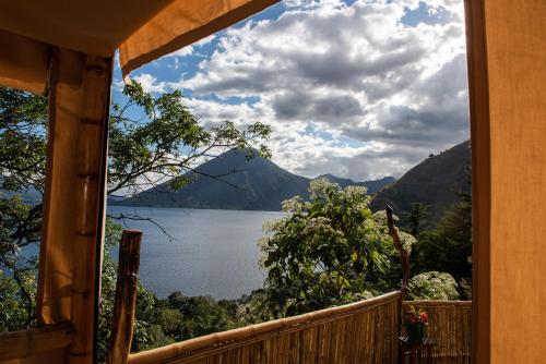 a view of a lake from a house window at EL PICNIC ATITLÁN in Tzununá