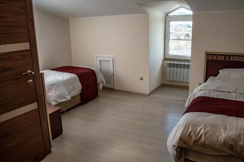 a room with two beds and a window at Stone Art Guest House & Camping in Pemzashen