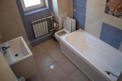 a bathroom with a tub and a toilet and a sink at Stone Art Guest House & Camping in Pemzashen