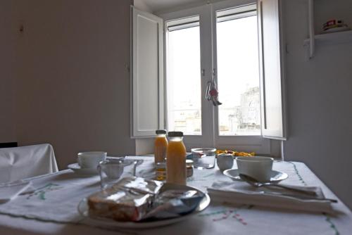 un tavolo con un piatto di cibo e una finestra di Casa 3Bien a Matera