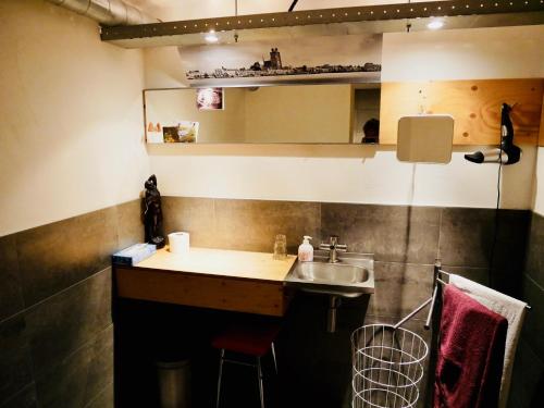 een kleine keuken met een wastafel en een spiegel bij StudioPlus in Dordrecht