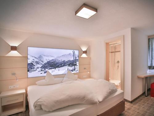 Schlafzimmer mit einem weißen Bett und einem TV an der Wand in der Unterkunft Glanzer Homes Hochsölden in Sölden