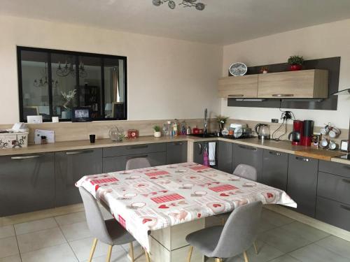 a kitchen with a table with a table cloth on it at Détente en Normandie in Damville