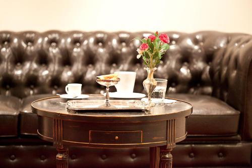 a coffee table with a vase of flowers on it at das HOTEL in München in Munich