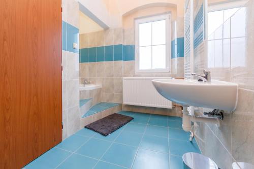 a bathroom with blue floors and a sink at Sherwood Hotel Vojkovice nad Ohří in Vojkovice