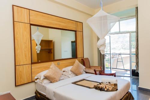 キガリにあるKigaliview Hotel and Apartmentsのベッドルーム(大きな鏡、ベッド付)
