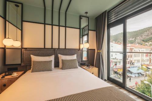 a bedroom with a large bed and a large window at City Life Demir Hotel in Fethiye