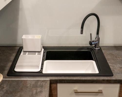 a kitchen counter with a sink with a cup on it at Apartament Relax in Skawina