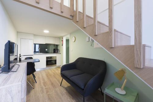 a living room with a couch and a staircase at Apartamentos do Prado In Douro in Vila Real