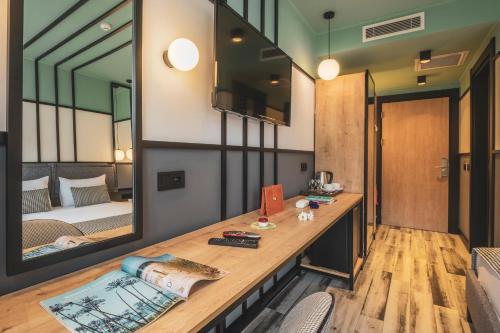 Zimmer mit einem Schreibtisch, einem Spiegel und einem Bett in der Unterkunft City Life Demir Hotel in Fethiye