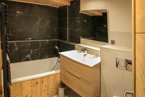 een badkamer met een wastafel en een bad bij Magnifique Appartement neuf de 60m2 Méribel centre in Les Allues