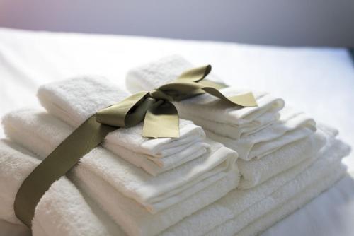 a stack of towels with a green ribbon on them at Apartamentos do Prado In Douro in Vila Real