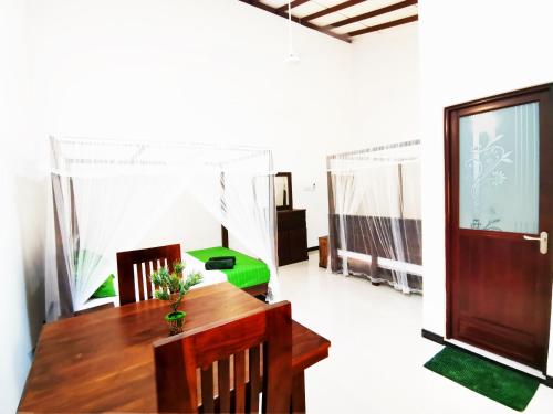 a dining room with a table and chairs and a door at Beach Breeze Weligama in Weligama