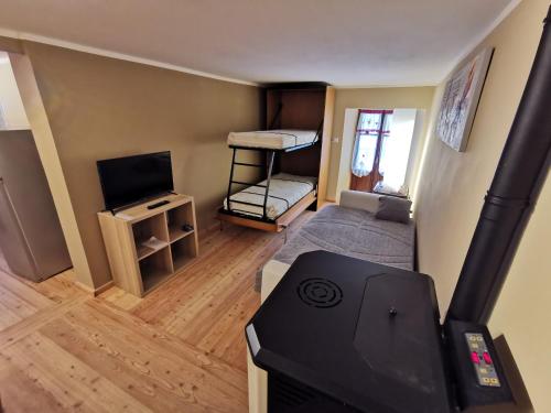 a small room with a bunk bed and a television at casa curnet in Balme