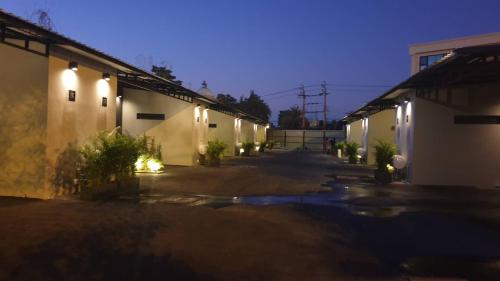 an empty courtyard of a building at night at Grand Park Resort in Ban Chorakhe Bua