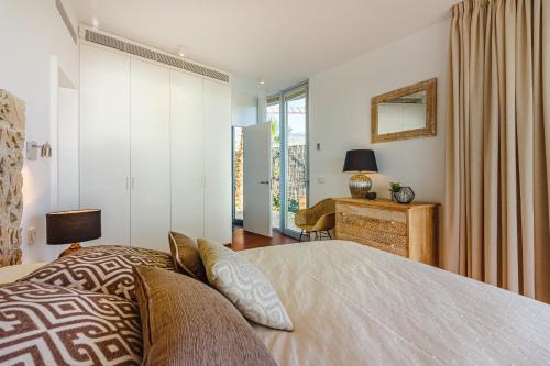 a bedroom with a bed and a desk with a mirror at Villa Abama Belle Vue in Playa de San Juan