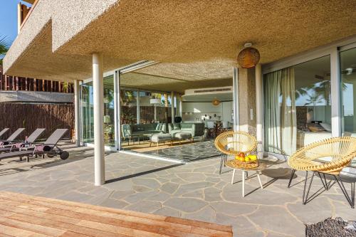 a patio with chairs and tables on a house at Villa Abama Belle Vue in Playa de San Juan