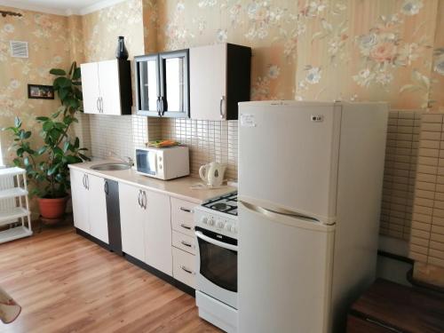 カリーニングラードにあるApartment on Gagarina 55Bのキッチン(白いキャビネット、白い冷蔵庫付)