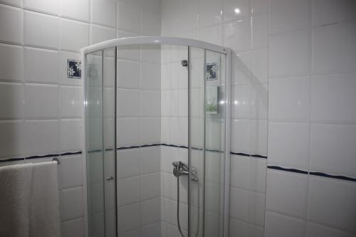 um chuveiro com uma porta de vidro na casa de banho em Hotel Avenida em Assomada