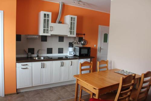 a kitchen with white cabinets and a wooden table at Słoneczna Zagroda - Sunny Ridge Farm in Łączna