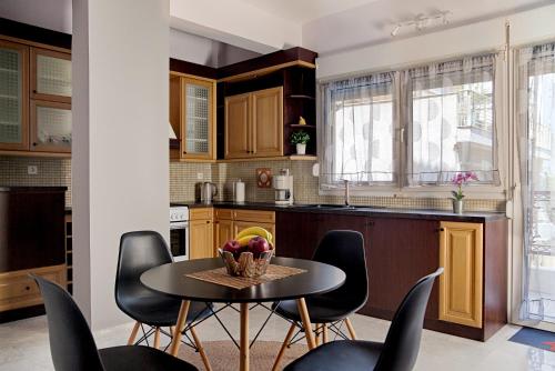 a kitchen with a table and black chairs at Dream Suite in Thessaloniki