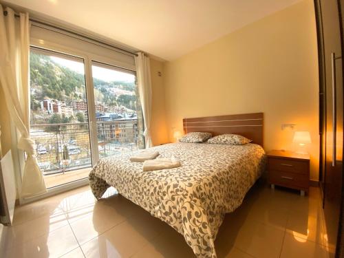a bedroom with a bed and a large window at Novell, Canillo centro, zona Grandvalira in Canillo