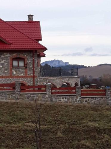 a building with a red roof on a field at Zamoček in Matiašovce