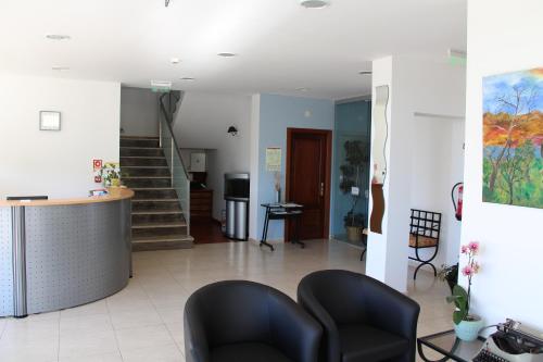 a waiting room with two chairs and a staircase at Hotel Minho Belo in Vila Nova de Cerveira