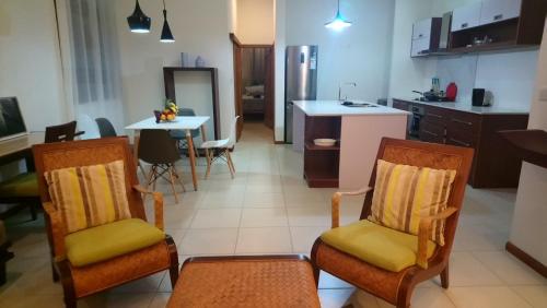 a kitchen with a table and chairs in a room at Les Villas Thorel in Rivière Noire